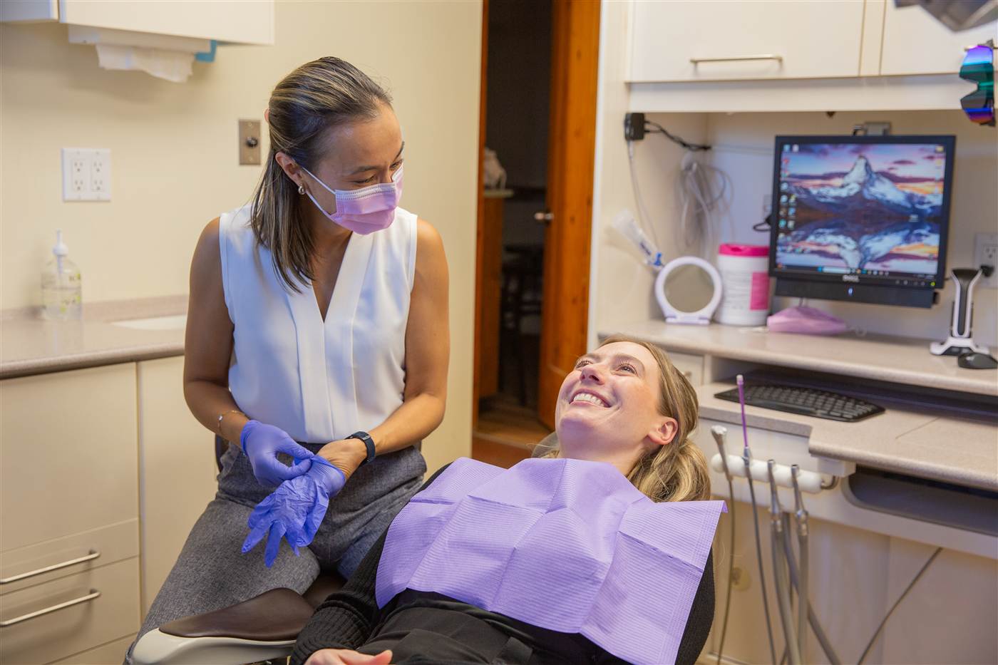 A dentist sharing a laugh with a patient before an exam